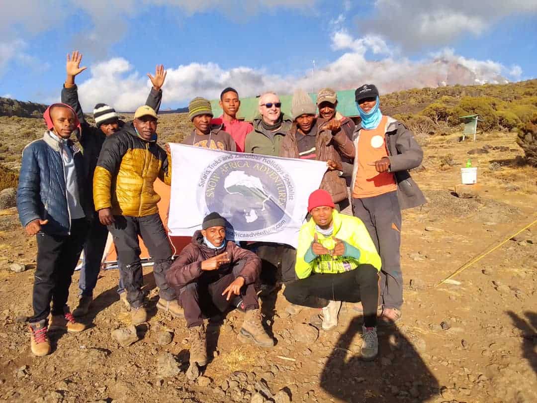 Kilimanjaro climbers at high-altitude camp with views of the summit zone